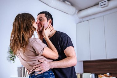 Sıcak ve sevgi dolu bir mutfakta bir çift kucaklaşır. Öpüşmek için eğilirler, Sevgililer Günü 'nü neşe ve sevgiyle kutlarlar, rahat bir atmosferle çevrili bir şekilde..