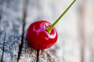 Kırmızı, sulu vişneli yakın plan. Ağaç kirazından dökülen eski ahşap arka planda.