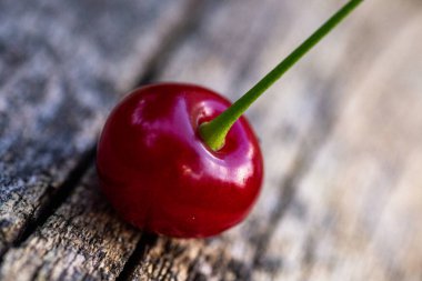 Kırmızı, sulu vişneli yakın plan. Ağaç kirazından dökülen eski ahşap arka planda.