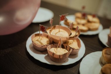 Beyaz tabakta nefis ev yapımı kekler, neşeli bayraklarla süslenmiş.. 