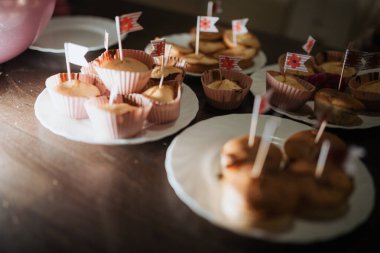 Küçük bayraklarla hazırlanmış lezzetli fırınlanmış ikramlar. Sıcak atmosfer, paylaşılan anların ve ev yapımı zevklerin altını çiziyor..