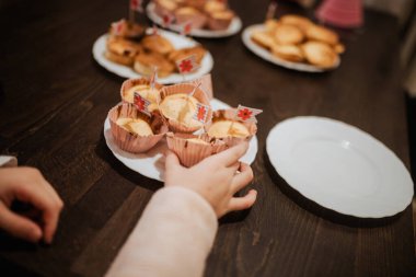 Bir el, aile toplantısı sırasında içi lezzetli yiyeceklerle dolu bir masadan çöreğe uzanır.. 