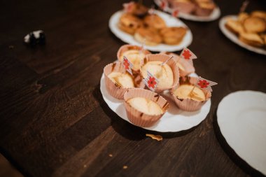 Bayraklarla süslenmiş minyatür pastalar da dahil olmak üzere çeşitli fırınlanmış yiyecekler sıcak ve kutlayıcı bir atmosfer yaratıyor..