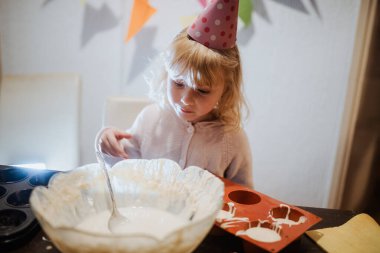 Canlı bir yemek pişirme seansında tatlı bir kız, malzemeleri karıştırıyor ve lezzetli bir ziyafet hazırlıyor.. 