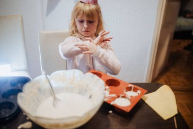 Genç bir çocuk hamur kalıbını dikkatlice pişirerek lezzetli yiyecekler yaratmaya odaklanıyor.. 