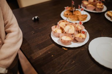 Çocuk, festival masasında tabaktan keke uzanıyor..