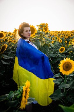 Özgürlük ve kimliği kutlayan Ukraynalı bir kadın, Bağımsızlık Günü 'nde bayrağıyla birlikte geleneksel giysiler içinde dimdik ayakta duruyor..