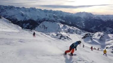 Snowboardcu Alpine Yamacında oyma yapıyor. Alplerde Kış Snowboard Macerası