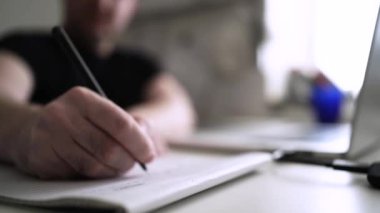 Düşüncelerini deftere kaydeden bir adam. Çünkü depresyonda, sorunları var ve psikoloğu olmadan bunu öğrenip kendine yardım etmek istiyor.
