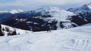 Snowboardcular Alplerin tozlu yamaçlarının tadını çıkarıyorlar.