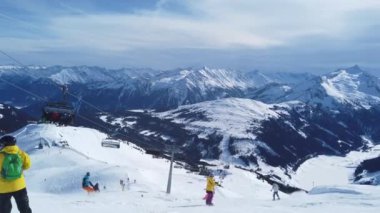 Snowboardcular Alplerin tozlu yamaçlarının tadını çıkarıyorlar.