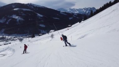 Snowboardcular Alplerin tozlu yamaçlarının tadını çıkarıyorlar.