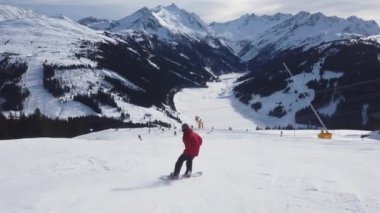 Snowboardcular Alplerin tozlu yamaçlarının tadını çıkarıyorlar.