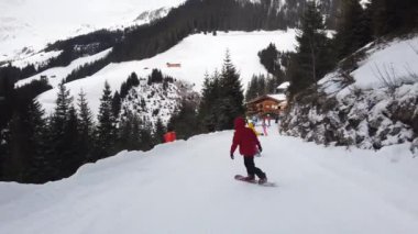 Snowboardcular Alplerin tozlu yamaçlarının tadını çıkarıyorlar.