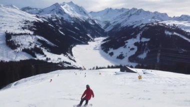 Snowboardcular Alplerin tozlu yamaçlarının tadını çıkarıyorlar.