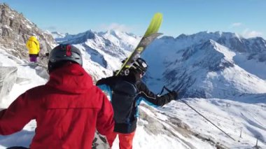 Snowboardcular Alplerin tozlu yamaçlarının tadını çıkarıyorlar.