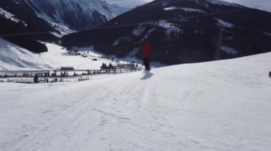 Snowboardcular Alplerin tozlu yamaçlarının tadını çıkarıyorlar.