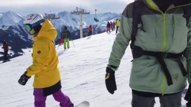 Snowboardcular Alplerin tozlu yamaçlarının tadını çıkarıyorlar.
