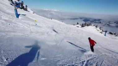 Snowboardcular Alplerin tozlu yamaçlarının tadını çıkarıyorlar.