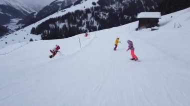 Snowboardcular Alplerin tozlu yamaçlarının tadını çıkarıyorlar.