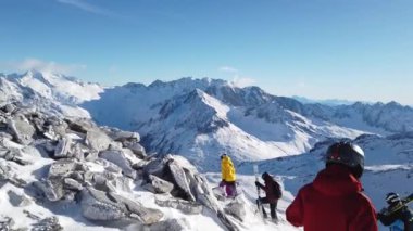 Snowboardcular Alplerin tozlu yamaçlarının tadını çıkarıyorlar.