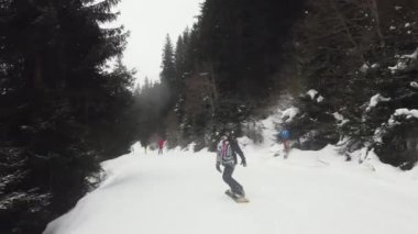 Snowboardcular Alplerin tozlu yamaçlarının tadını çıkarıyorlar.