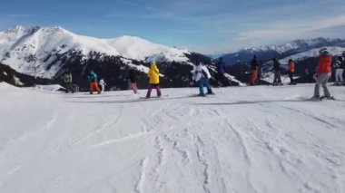 Snowboardcular Alplerin tozlu yamaçlarının tadını çıkarıyorlar.