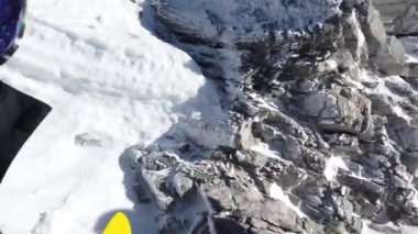 Snowboardcular Alplerin tozlu yamaçlarının tadını çıkarıyorlar.