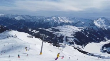 Snowboardcu Alplerin tozlu yamaçlarının tadını çıkarıyor.