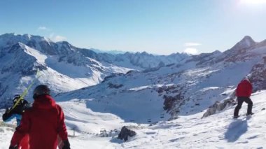 Snowboardcu Alplerin tozlu yamaçlarının tadını çıkarıyor.
