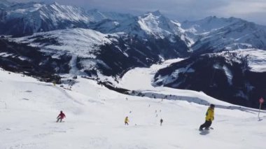 Snowboardcu Alplerin tozlu yamaçlarının tadını çıkarıyor.