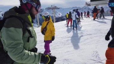 Snowboardcu Alplerin tozlu yamaçlarının tadını çıkarıyor.