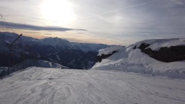 Snowboardcu Alplerin tozlu yamaçlarının tadını çıkarıyor.