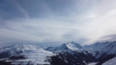 Snowboardcu Alplerin tozlu yamaçlarının tadını çıkarıyor.