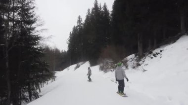 Snowboardcu Alplerin tozlu yamaçlarının tadını çıkarıyor.