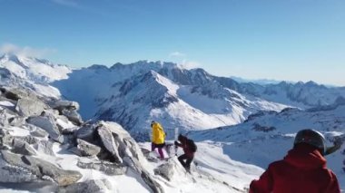 Snowboardcu Alplerin tozlu yamaçlarının tadını çıkarıyor.