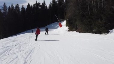 Snowboardcu Alplerin tozlu yamaçlarının tadını çıkarıyor.