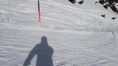 Snowboardcu Alplerin tozlu yamaçlarının tadını çıkarıyor.