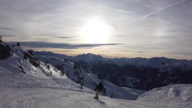 Snowboardcu Alplerin tozlu yamaçlarının tadını çıkarıyor.
