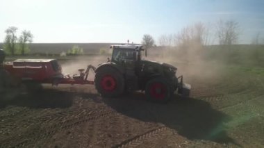 İlkbaharda Ukrayna 'da tarla ekme şeker pancarı üzerinde çalışan yeşil traktör