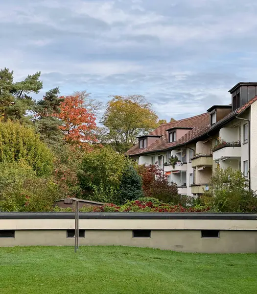 Bern 'de balkonları olan yerleşim yerleri İsviçre' de verimli sonbahar ağaçları ve yeşil çimlerle çevrili. Sahne, sakin bir ortamda doğa ve mimarinin karışımını vurguluyor..