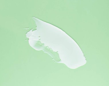 Yeşil arka planda yüz ve vücut için beyaz krem kokusu