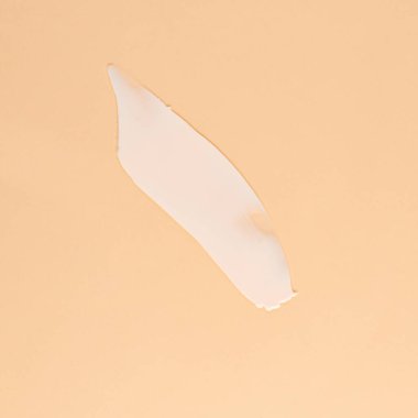 Kahverengi arka planda yüz ve vücut için beyaz krem kokusu