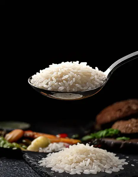 Koyu bir arka planda kaşıkta yakın plan pirinç. Yemek blogcuları için harika resimler.