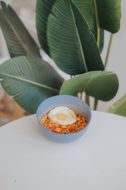 Beyaz bir masada beyaz bir kasede pirinçli yumurta..