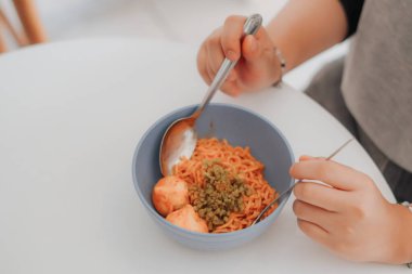 Masada spagetti yiyen kadın.