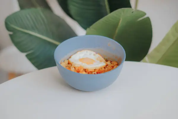 Beyaz tabakta yumurta sarısı, mavi pirinç ve yumurta.