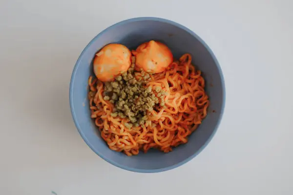 Beyaz arka planda tavuk etli ve yumurtalı makarna.