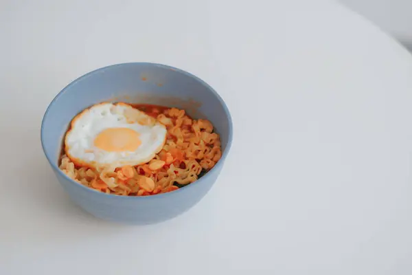 Bir kase ve bir kaşık ile dikey çekim ve bir plaka ile beyaz bir plaka ile kızarmış yumurta