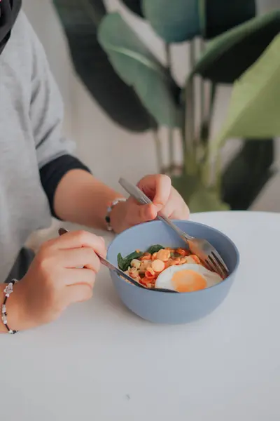 Asyalı bir kadın kaşıkla lezzetli pirinç eriştesi, bir kase sebze ve çubuk yiyor, Asya mutfağı konsepti.
